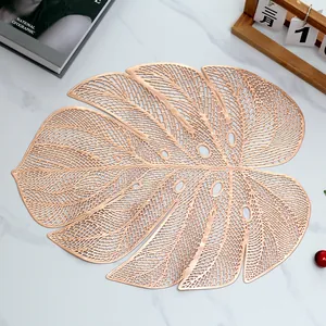Monstera leaf PVC heat-resistant gold table mat on white marble background