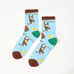 Detail of light blue crew socks with cartoon monkey and banana patterns and brown accents