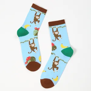 Detailed view of blue crew socks with cartoon monkey, banana and hibiscus floral patterns