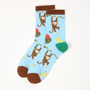 Detail of light blue crew socks with cartoon monkey, banana and flower patterns