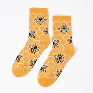 Detail of bee and honeycomb pattern on yellow crew socks with soft cotton texture