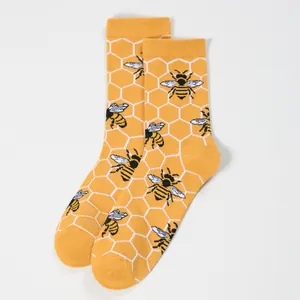 Detail of yellow cotton mid-calf socks with honeycomb patterns and honey bee prints