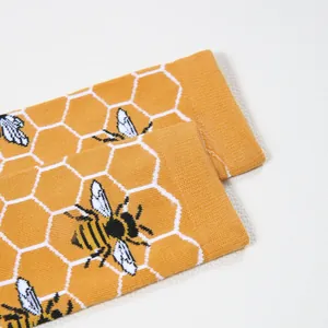 Detailed close-up of ribbed cuffs and bee embroidery on bright orange cotton socks