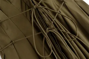 Detail der Kreuzschnürung mit Faltenstoff an einem dunkelolivgrünen Kleid