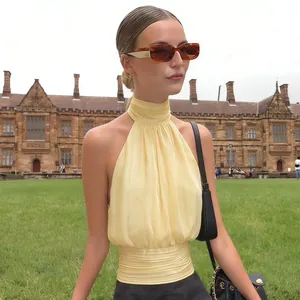 Détail du haut dos nu jaune avec tissu plissé et design à taille ajustée élégant