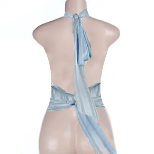 Détail du haut dos nu en satin bleu clair avec des lacets réglables à la taille