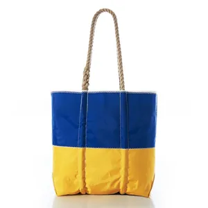 Close-up of blue and yellow tote bag with thick rope handles on a white background