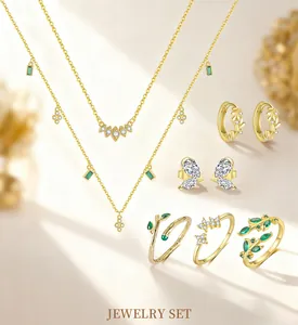 Nahaufnahme eines goldenen Schmucksets mit grünen Kristallen und Blattform-Details