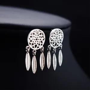 Boucles d'oreilles attrape-rêves bohèmes avec plumes argentées sur présentoir noir