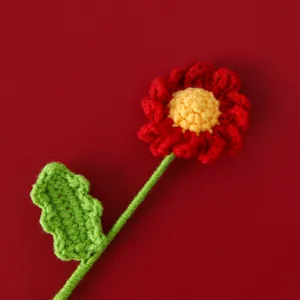 Détail macro d'une fleur de marguerite faite au crochet avec pétales rouges et texture