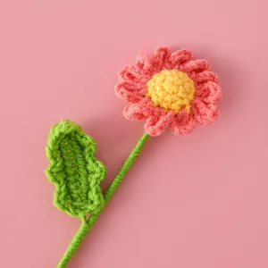 Gros plan d'une fleur de marguerite faite main au crochet aux pétales roses