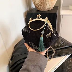 Detail of black velvet handbag with golden crane embroidery and vintage clasp