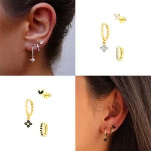 Détail des boucles d'oreilles trèfle et de l'ensemble de créoles en strass