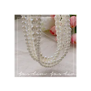 Close-up of elegant four-layer pearl necklace with soft white luster on linen background