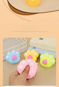 Detail showing hand squeezing colorful cat paw squishy toys with slow rebound texture