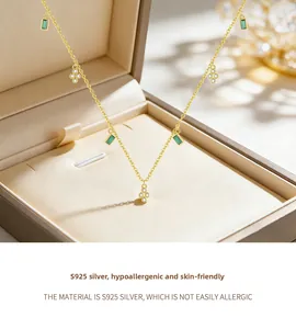 Nahaufnahme der S925 Silber Goldkette mit smaragdgrünem Anhänger und Blumen-Details am Band