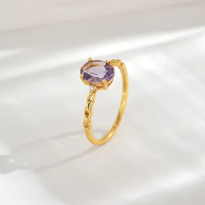 Detail of 18K gold plated S925 silver ring featuring an oval purple gemstone and chain band
