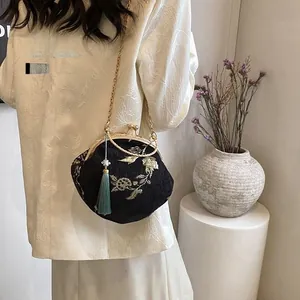Detail of Chinese style embroidery bag with gold floral patterns and silk tassel