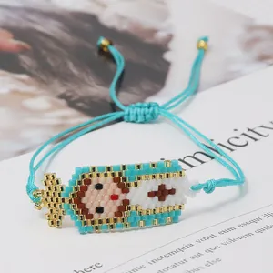Detail of handmade woven Miyuki bead bracelet featuring a cartoon Madonna icon with blue cord