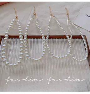 Detail view of four graduated cream pearl necklaces with adjustable gold lobster clasps