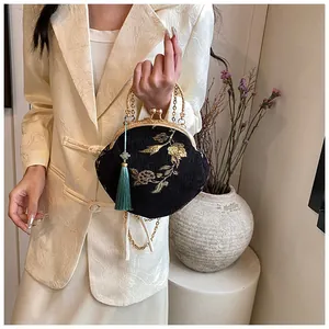 Detailed close-up of a black Hanfu bag featuring golden floral embroidery and a blue tassel