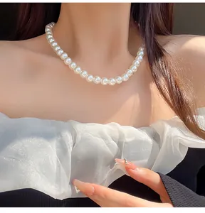 Close-up of white pearl necklace on model neck with elegant off-shoulder white top