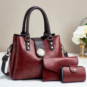 Three-piece burgundy faux leather handbag set with tote, envelope wallet and card holder