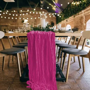 Detail of magenta cheesecloth table runner with natural wrinkled texture for wedding decor
