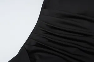 Detailed close-up of refined ruched pleats on a black elegant summer dress fabric