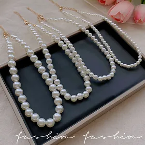 Elegant tiered pearl necklaces with golden lobster clasps on a stylish display tray