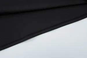 Close-up of double-needle stitching and fine fabric texture on a black summer dress
