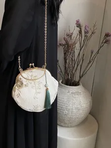 Octagonal Chinese style embroidered crossbody bag with floral patterns and green tassel