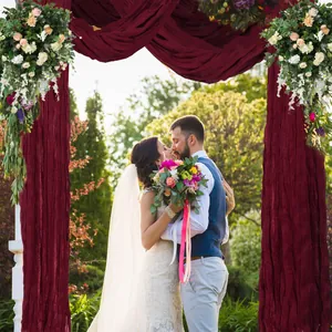 Detail of wine red cheesecloth wedding arch draping fabric with elegant pleated texture
