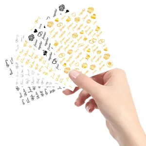 Close-up of gold, silver, and black nail art stickers with roses and heart designs
