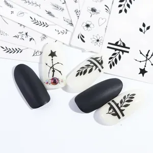 Detailed view of black floral and leaf nail stickers on matte and glossy nail tips