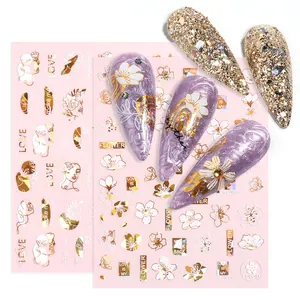 Gold abstract face and floral nail stickers on purple marble manicure display