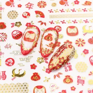Details von Neujahrs-Nagelaufklebern mit roten und goldenen Kranichen und Festmotiven