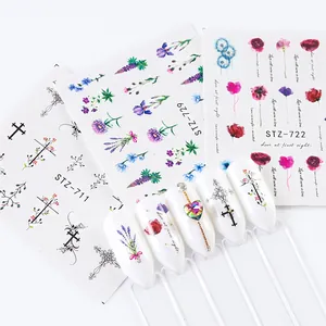 Detailed view of floral and cross nail stickers with real application on white tips