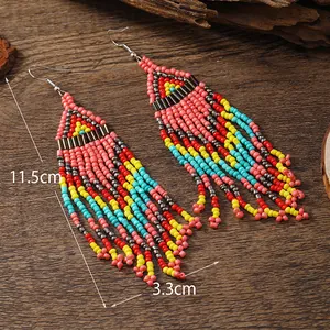 Detail view of colorful bohemian beaded tassel earrings showing 11.5cm length on wood