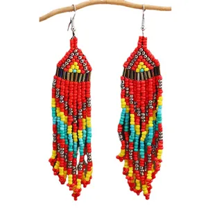 Handmade Bohemian beaded tassel earrings with geometric patterns on a wooden display