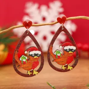 Detalle de pendientes de madera de Navidad con forma de gota, pájaro festivo y corazón rojo