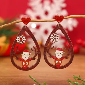 Detalle macro de pendientes de Navidad de madera con diseño de reno en rama invernal