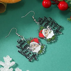 Macro-opname van grappige kerstman acryl oorbellen met rode bessen op groene achtergrond