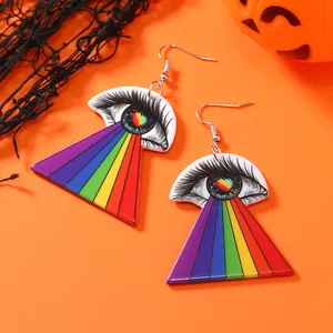Detail of acrylic eye earrings with rainbow rays against a festive Halloween backdrop