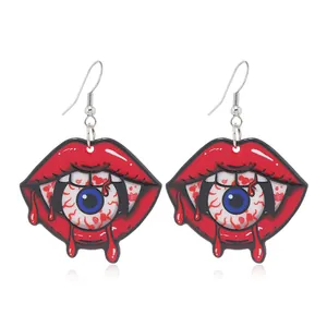 Detailed view of Halloween earrings featuring bloodshot eyeballs and red lips on white background