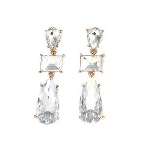 Vue macro de boucles d'oreilles géométriques dorées avec cristaux étincelants taillés