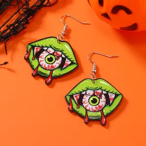 Spooky Halloween mouth and eyeball acrylic hook earrings on a vibrant orange backdrop