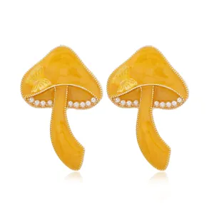 Pendientes de hongo amarillo con detalle de mariposa y bordes de perlas finas
