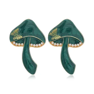 Detalle de pendientes de hongo verde oscuro con textura de mármol y perlas