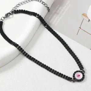 Detail view of black rhinestone choker with round pink stone pendant and lobster clasp
